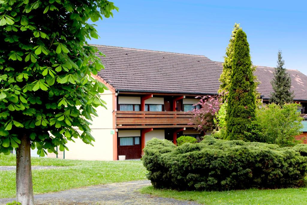 a house with a tree in front of it at Kyriad Direct Saint-Dizier in Saint-Dizier