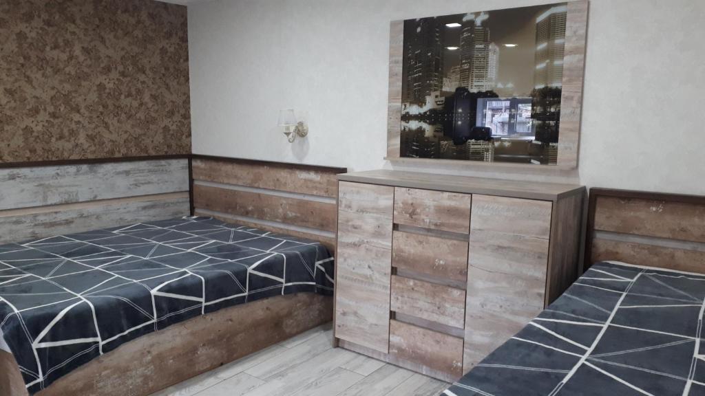 um quarto com 2 camas e uma televisão em Апартаменты студия, 10мин до центра, онкоцентр, томоклиника, em Kirovohrad