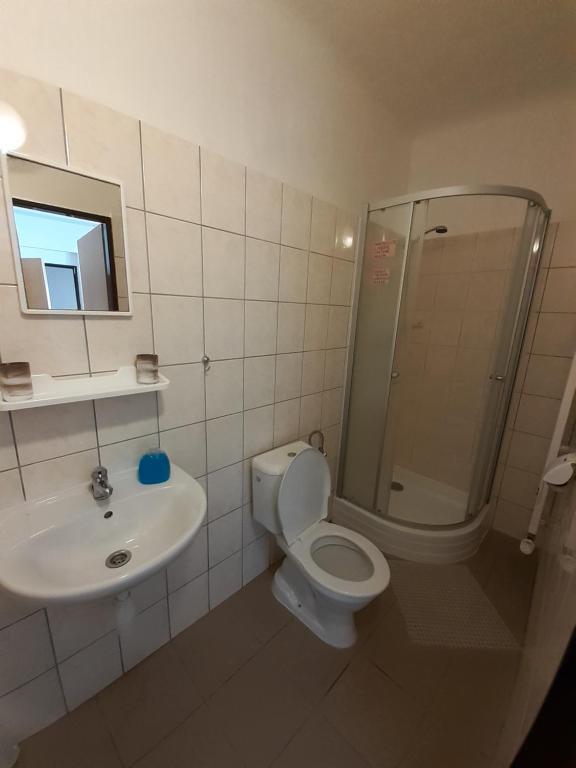 un bagno con doccia, WC e lavandino di Penzion Fontána a Mikulov