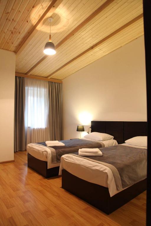 una camera da letto con due letti e una finestra di Hotel Chubu a Mestia