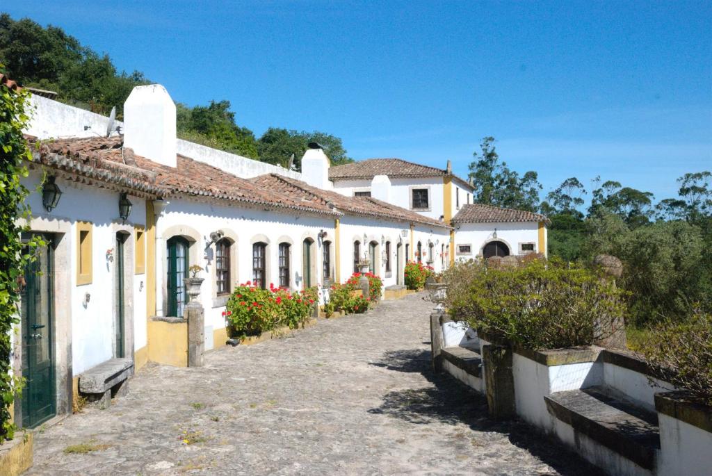 a row of white and yellow houses on a street at Quinta do Brejo - Turismo Equestre in Mafra