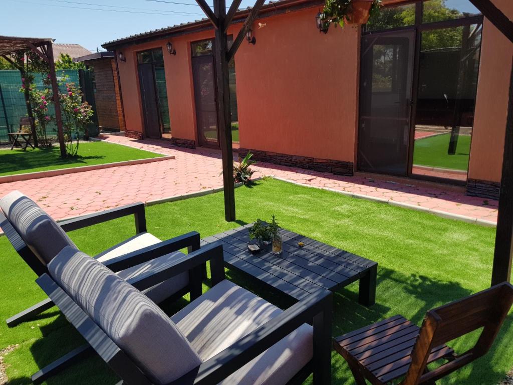 a patio with a table and chairs in a yard at Casa Gabriela Corbu in Corbu