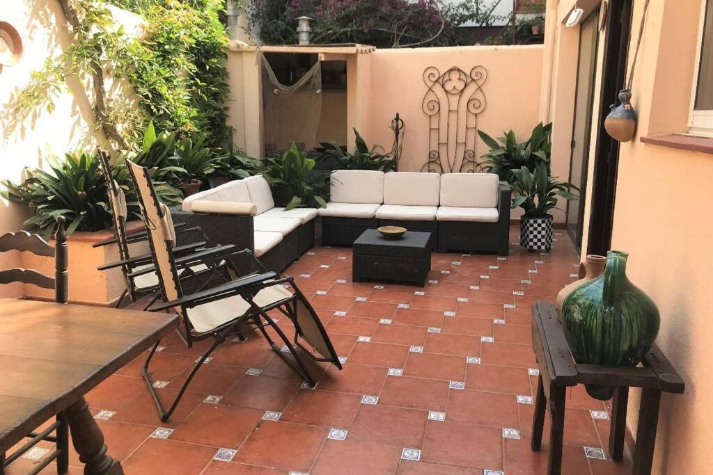 a patio with a couch and a table and chairs at Casa familiar decimonónica con mucho encanto in Sant Feliu de Guíxols