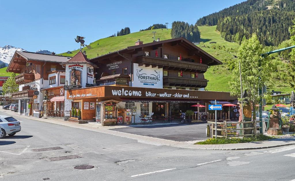 ein Gebäude an der Seite einer Straße mit einem Berg in der Unterkunft Ski & Bike Appartements Forsthaus in Saalbach-Hinterglemm