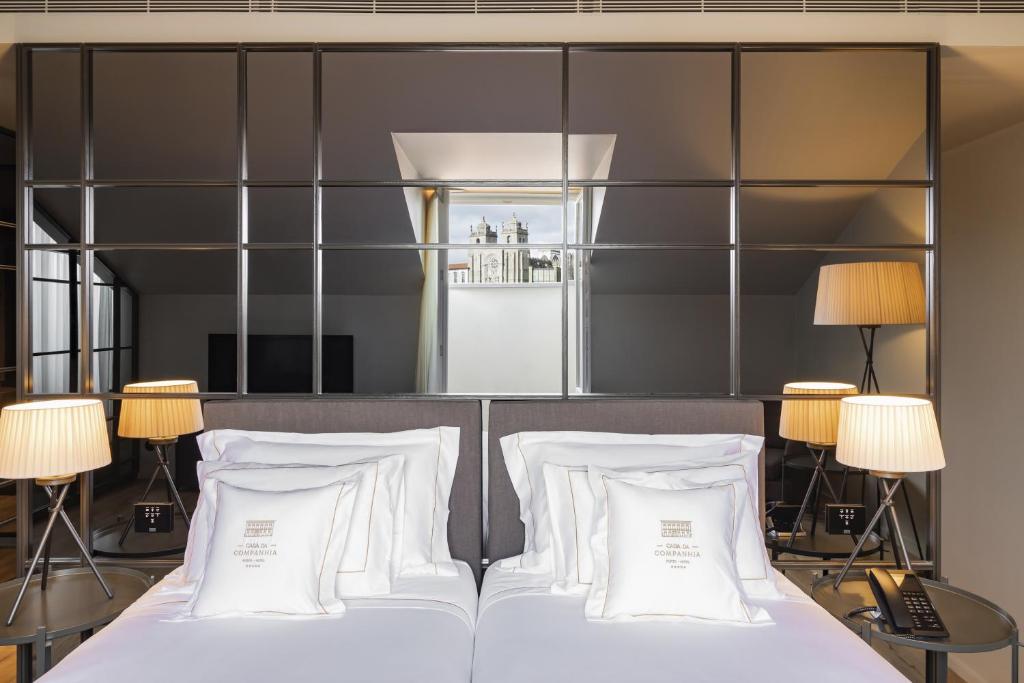 a bedroom with a bed with white pillows at Casa da Companhia, Vignette Collection by IHG in Porto