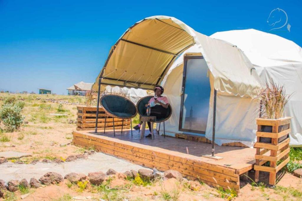 a man sitting in a tent in the desert at Amanya Camp 1 Double -Bed Tiger in Amboseli in Amboseli