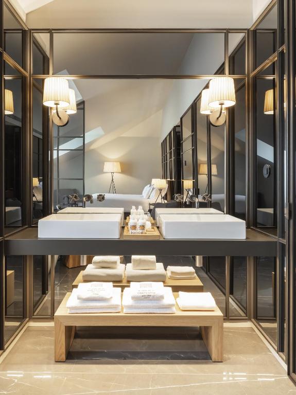 a bathroom with two sinks and two mirrors at Casa da Companhia, Vignette Collection by IHG in Porto