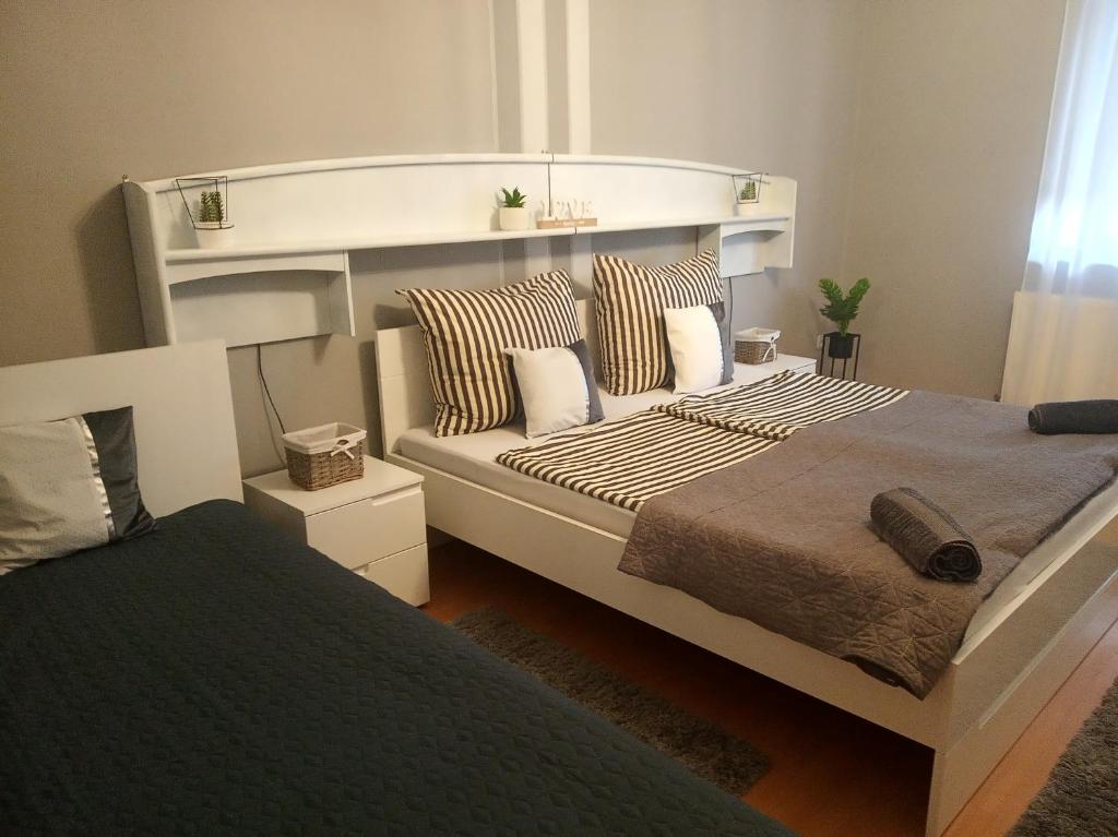 um quarto com uma cama grande e um sofá em Kaland vendégház em Sátoraljaújhely
