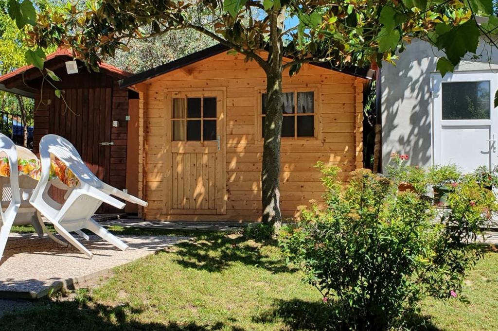 a log cabin with a chair and a shed at New Eco bungalow in Portorož