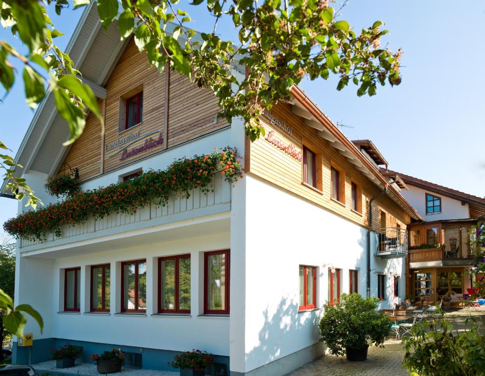 um edifício branco com um telhado de madeira em Landgasthof Lusenblick em Grafenau