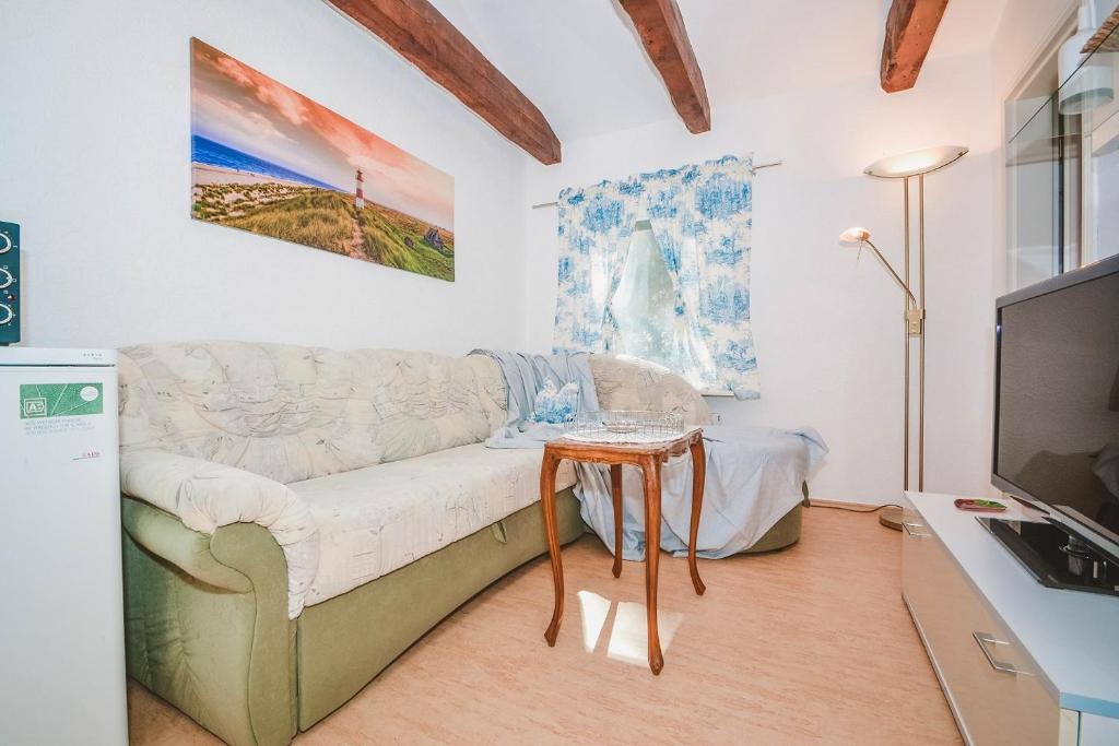 ein Wohnzimmer mit einem Sofa und einem Tisch in der Unterkunft Haus Mertin Whg 4 Seepferdchen in Heringsdorf