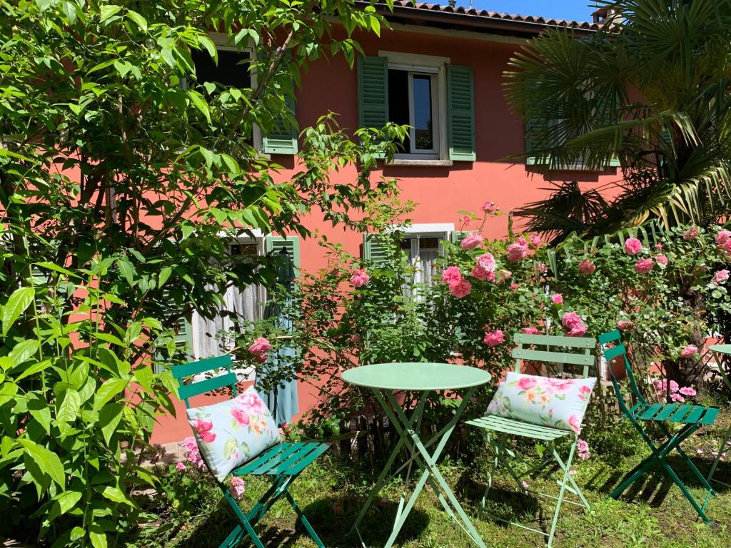 a table and chairs in front of a pink house at Il Giardino Segreto Arona, Charming Apartments in Arona
