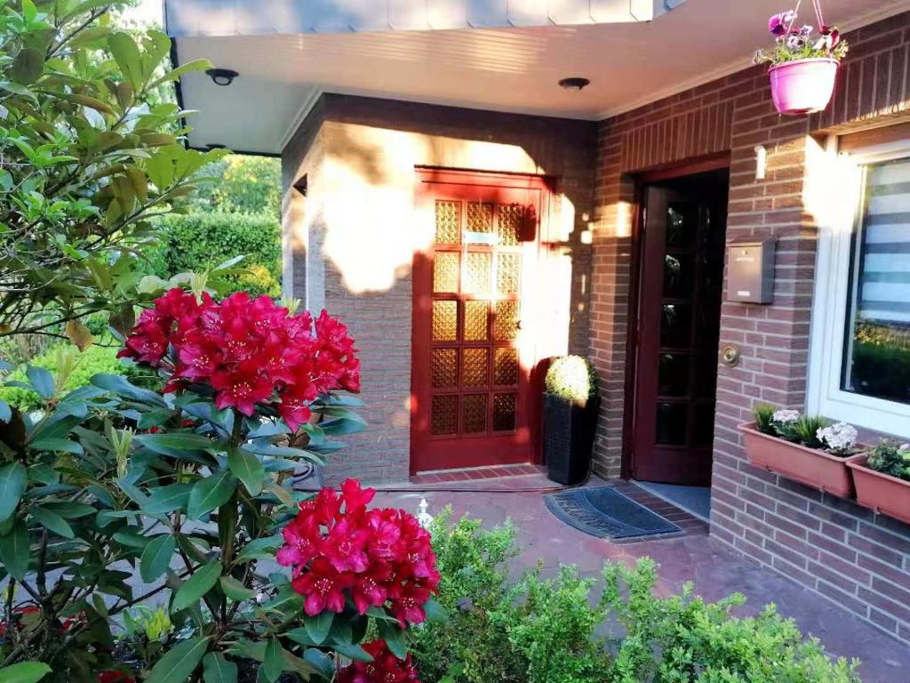 a front door of a house with red flowers at Appartment Daji in Lüneburg