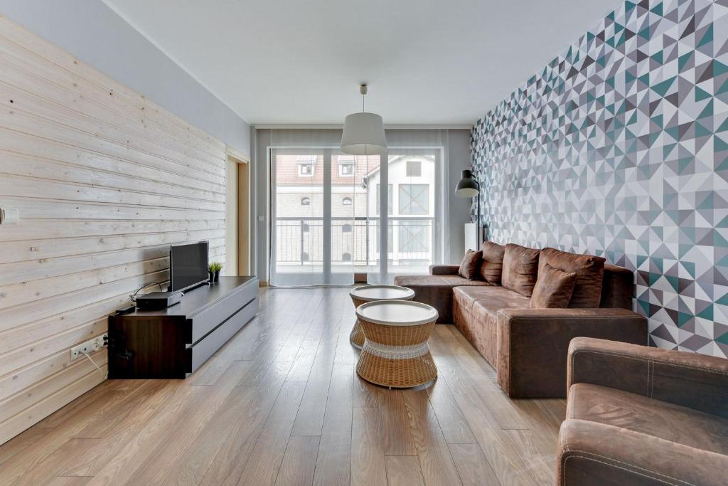 - un salon avec un canapé et une télévision dans l'établissement Grand Apartments - Davos Apartment Gdańsk Szafarnia River View, à Gdańsk