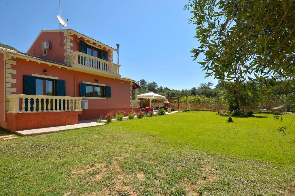 a house with a large yard with a grass field at La Casa Del Sole in Halikounas