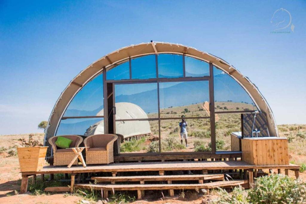 安博塞利的住宿－Amanya Camp 1-Bed Tent Elephant Suite in Amboseli，圆顶房子,有一个人站在窗户上