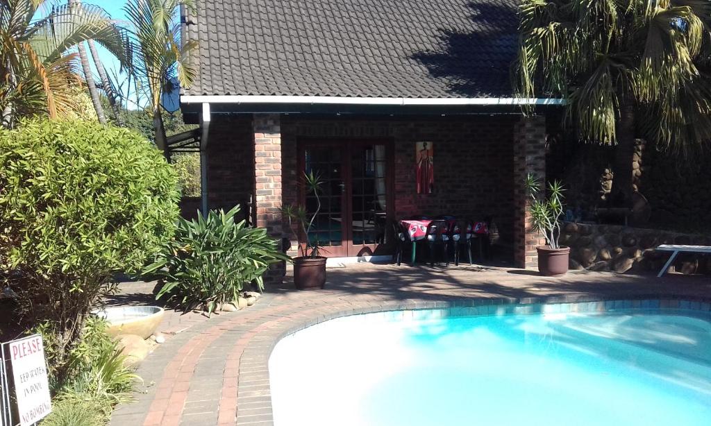 a swimming pool in front of a house at Smiths Cottage in Durban
