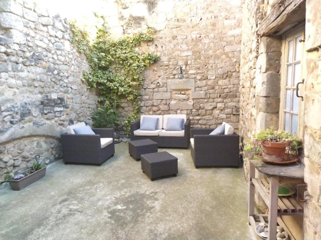 eine Terrasse mit Sofas und Ziegelwand in der Unterkunft Appartement au coeur du village- Ref12 in Saint-Paul-Trois-Châteaux