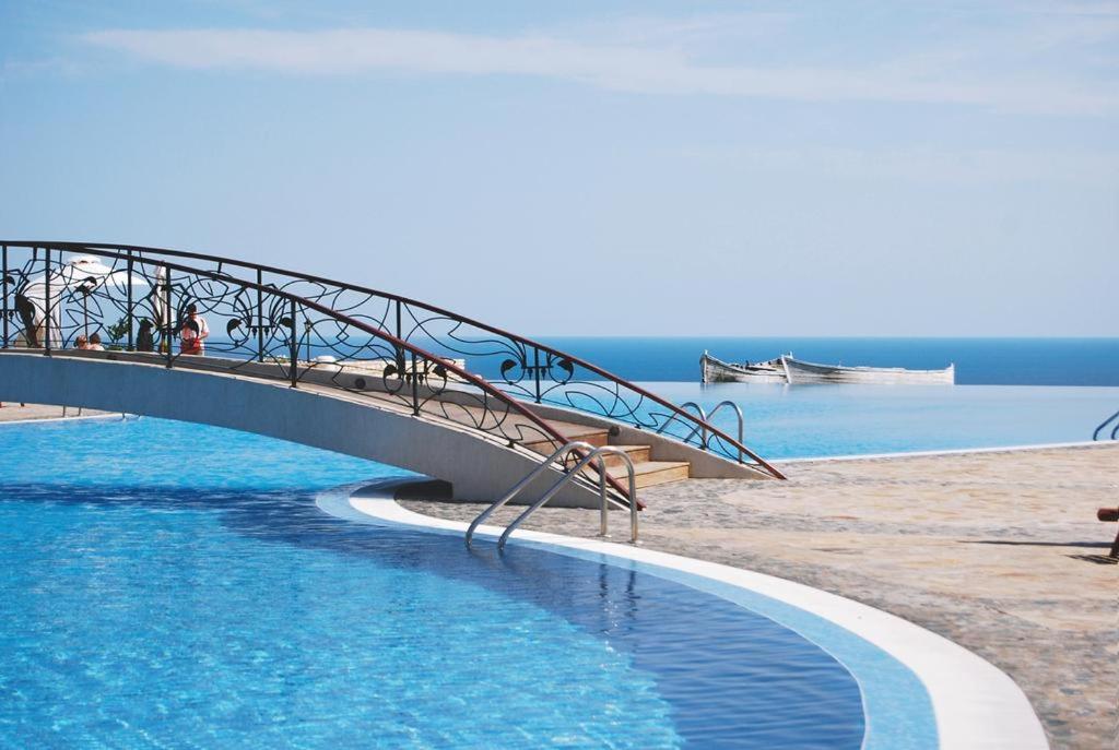 a bridge over a swimming pool next to a beach at Happy Studio Sea View in Topola