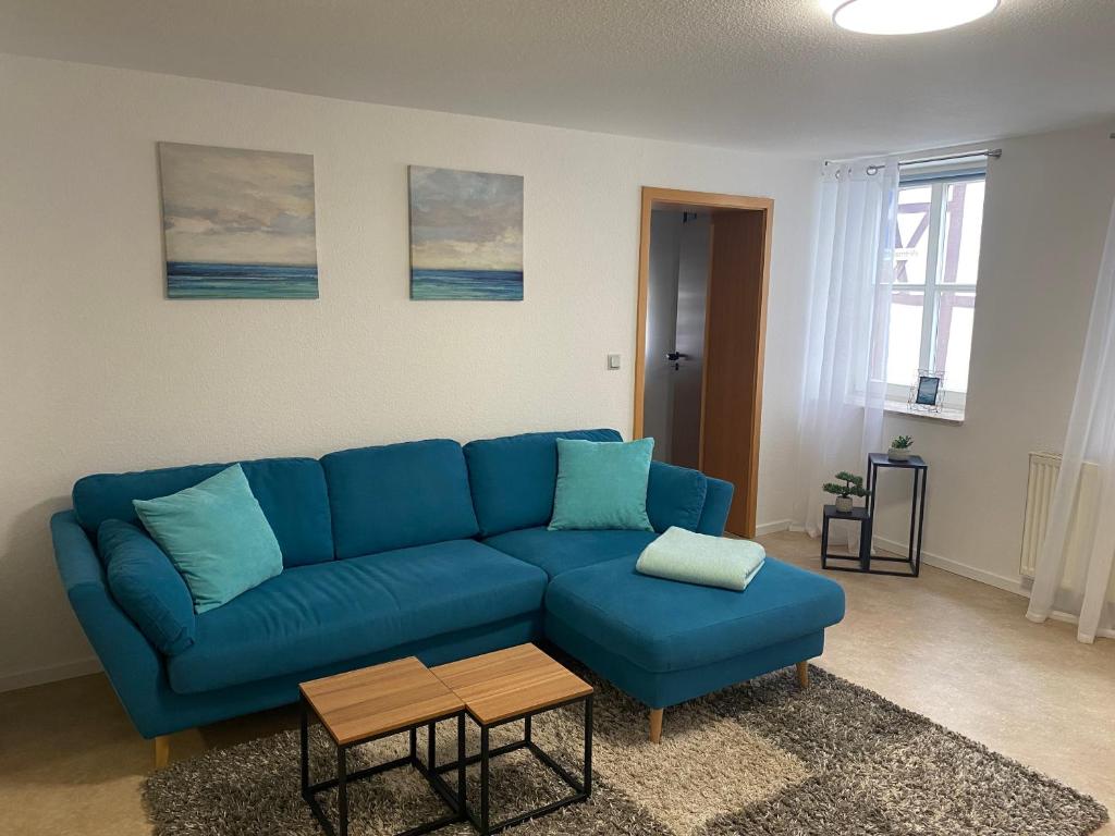 a living room with a blue couch and a table at Apartment Häuserstraße 15 in Northeim