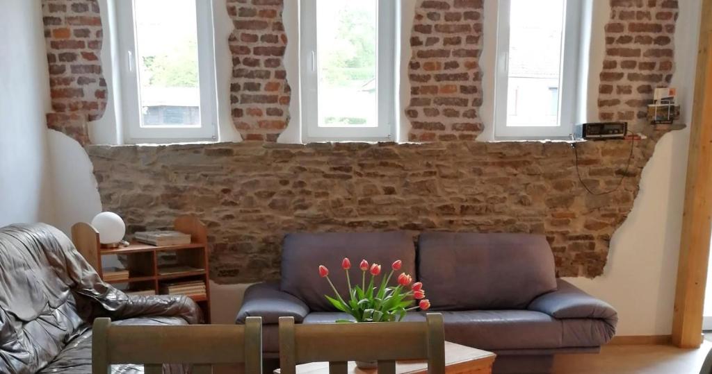 a living room with a couch and a brick wall at Isi-Hof 