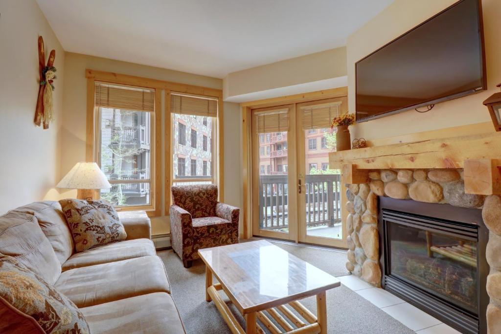 a living room with a fireplace and a tv at Tx212 Taylors Crossing Condo in Copper Mountain