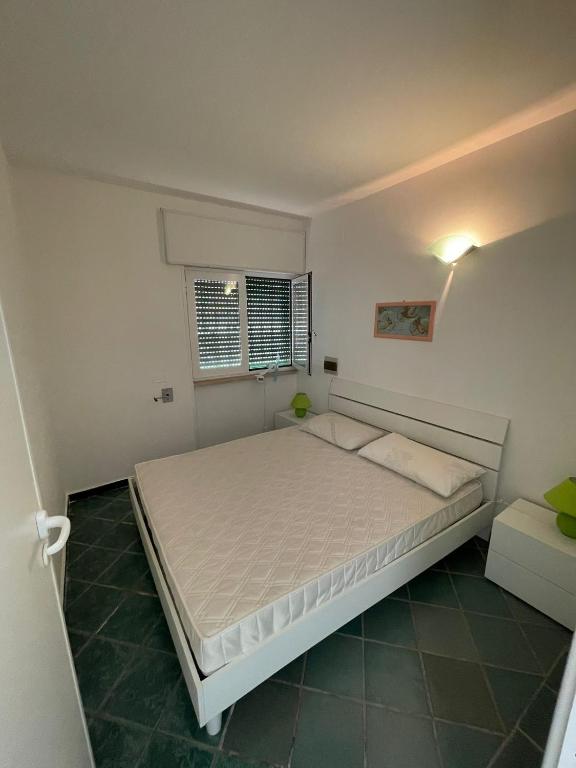 ein Schlafzimmer mit einem großen Bett und einem Fenster in der Unterkunft la seconda casa d'Amare in Torre Suda