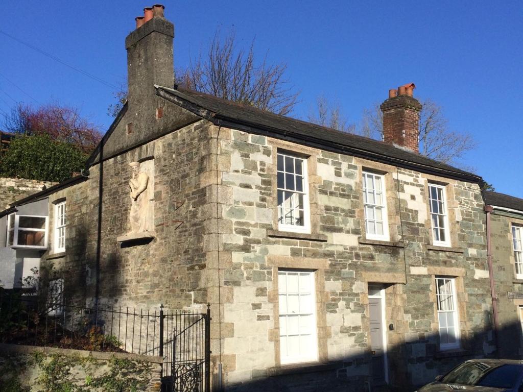an old stone building with two chimneys on it at Tavistock Town House in Tavistock