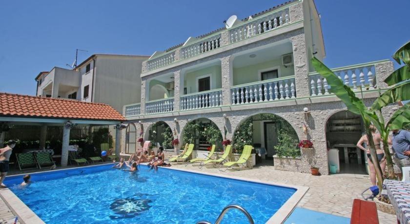 a group of people in a swimming pool next to a building at Room in Medulin with terrace, air conditioning, WiFi 3488-6 in Medulin