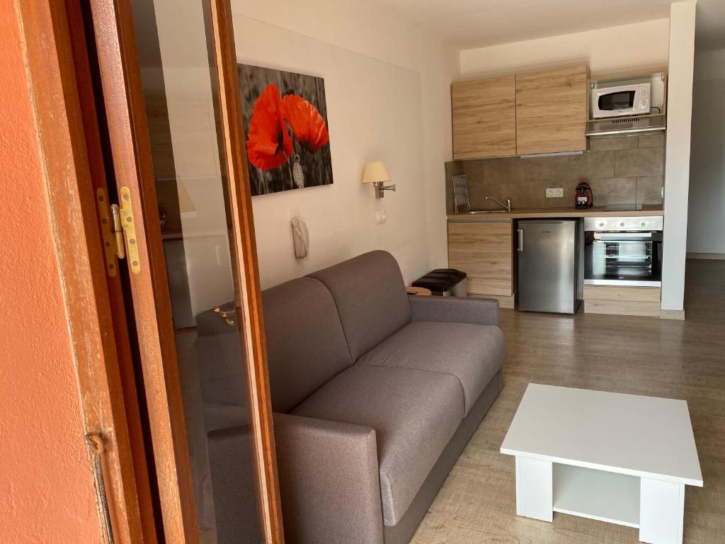 a living room with a couch and a kitchen at Apparthotel Le Porto in Porto Ota