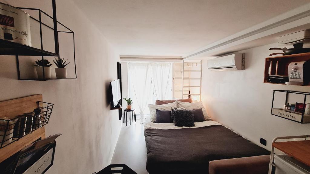 una piccola camera con un letto in una stanza con finestra di Casa nostra Capodistria a Capodistria