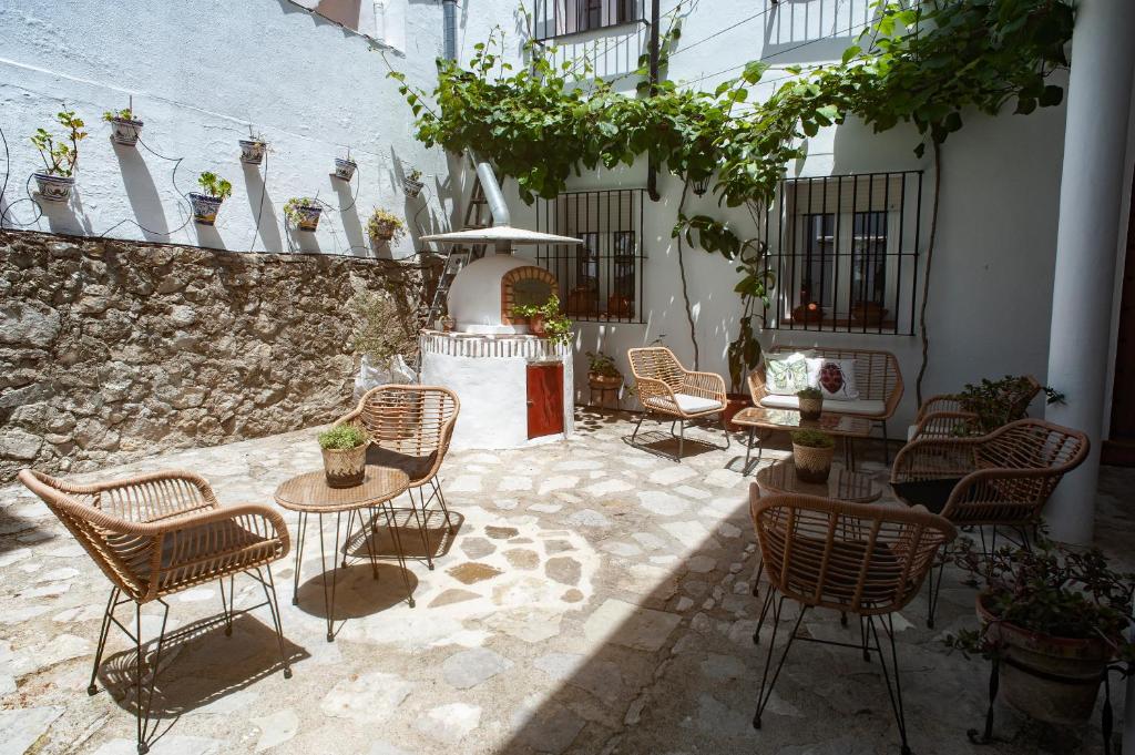 eine Terrasse mit Stühlen, Tischen und einem Brunnen in der Unterkunft La casa de la abuela Regina in Grazalema