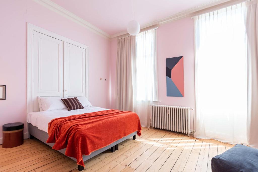 um quarto com uma cama com um cobertor vermelho em Smartflats Design - Theatre em Antuérpia