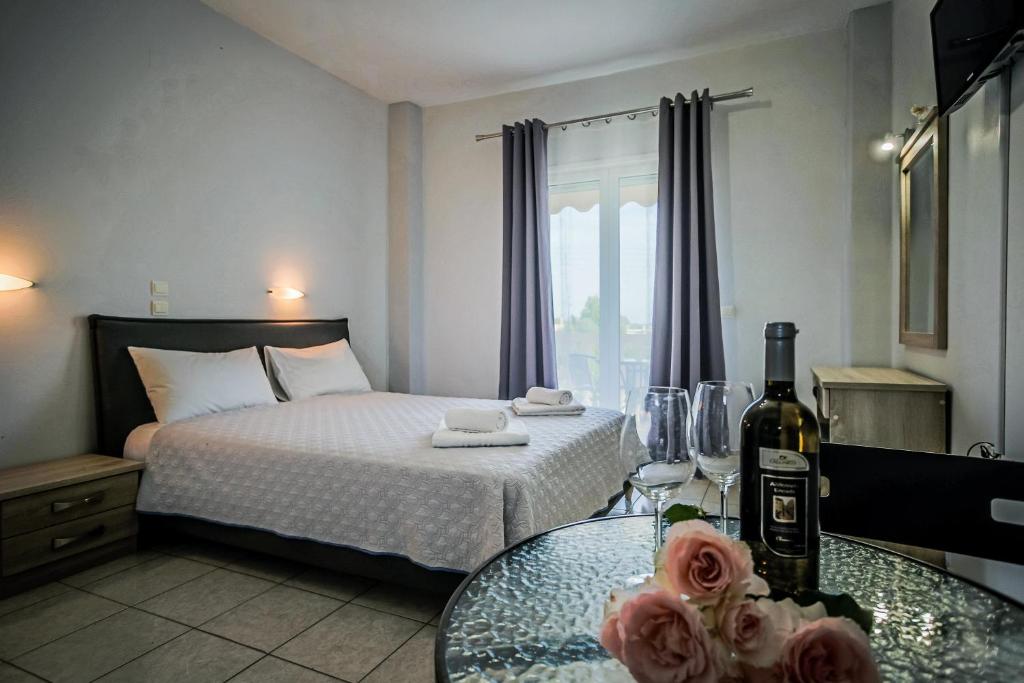 a bedroom with a bed and a table with a bottle of wine at Yria ntn Studios in Vanáton