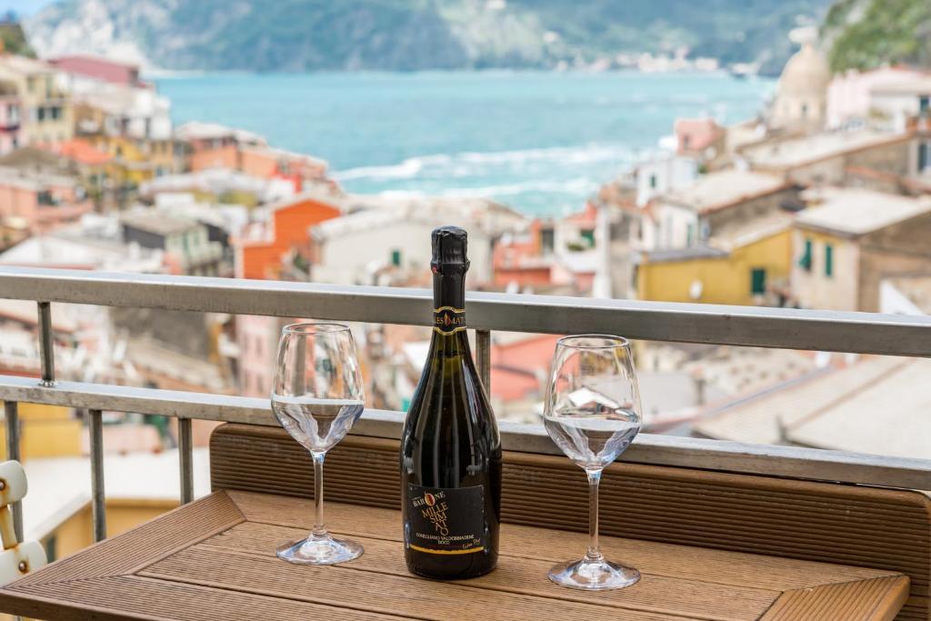 uma garrafa de vinho sentada numa mesa com dois copos de vinho em Casa Catò em Vernazza