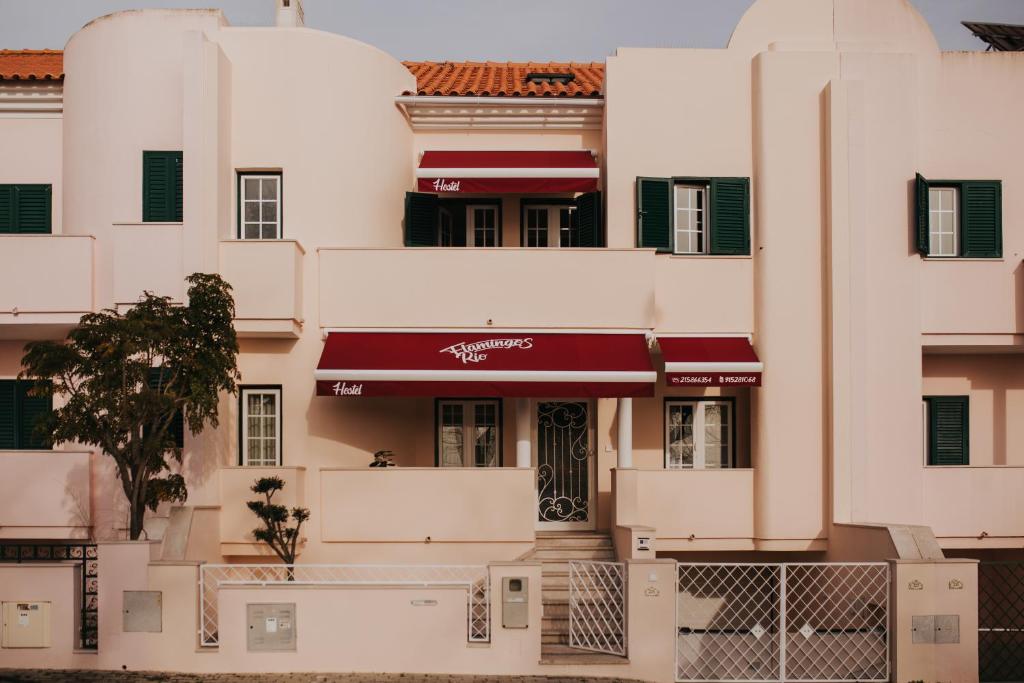 a large white building with a red awning at flamingos rio in Montijo