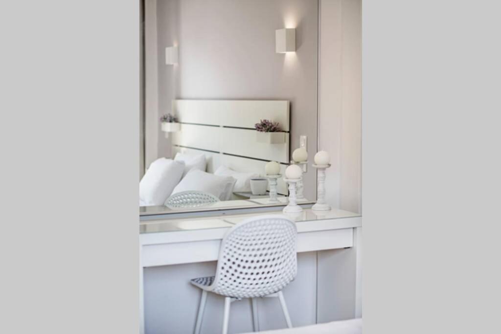 um toucador com uma cadeira e um espelho em E & G - Figareto Apartment em Kanoni