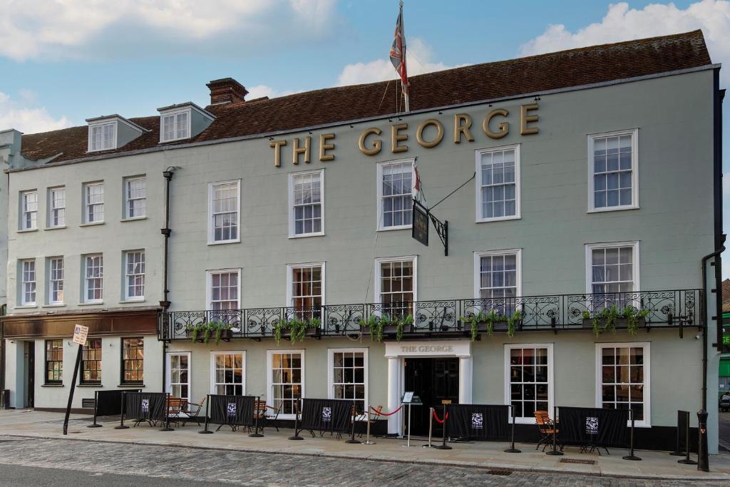 a white building with a sign that reads the george at The George Hotel in Colchester