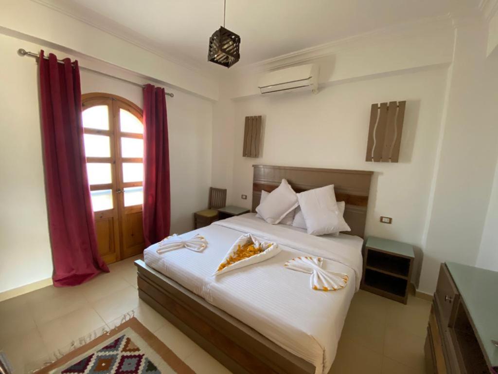 a bedroom with a large bed with a window at Villa 22 in Dahab