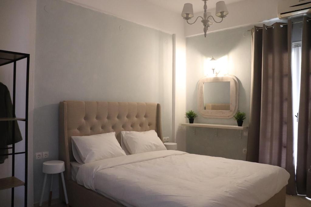 1 dormitorio con cama blanca y espejo en Nerajoula House, en Parga