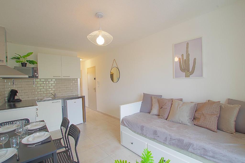 un salon avec un canapé et une table dans l'établissement T2 Climatisé à 5 min de la Plage 'Calme & Confort' - 5, à Canet