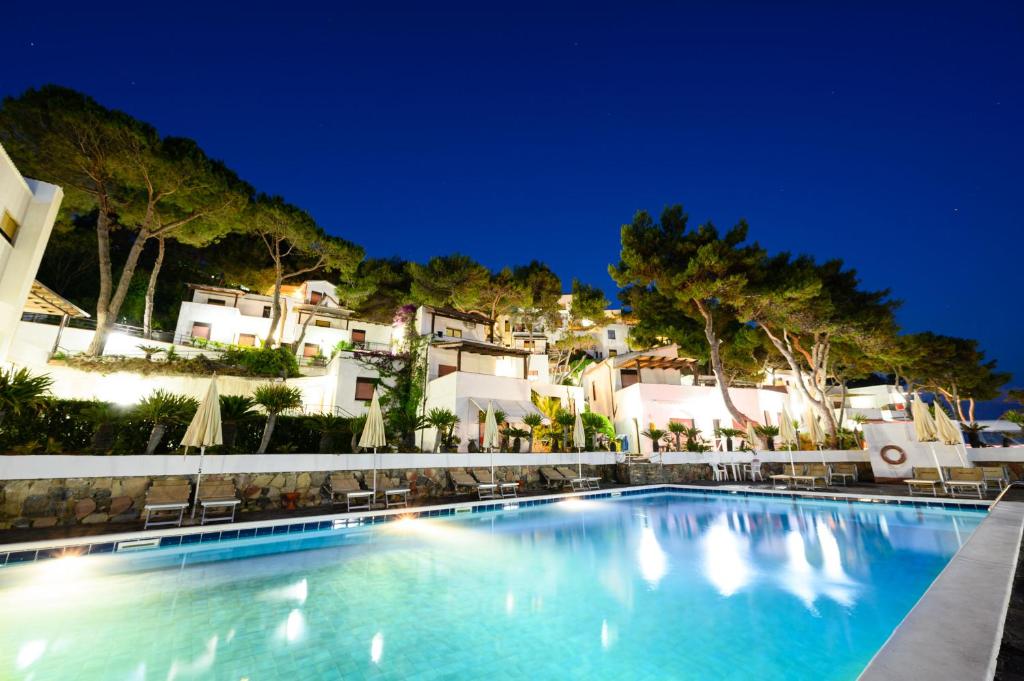 uma piscina em frente a um resort à noite em Villaggio Stella del Sud & Resort em Pisciotta