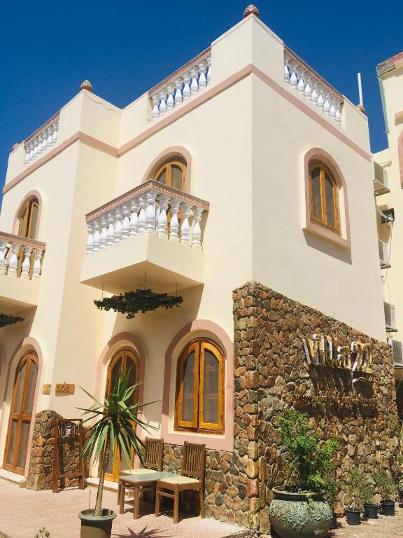 a large white house with a stone wall at Villa 22 in Dahab