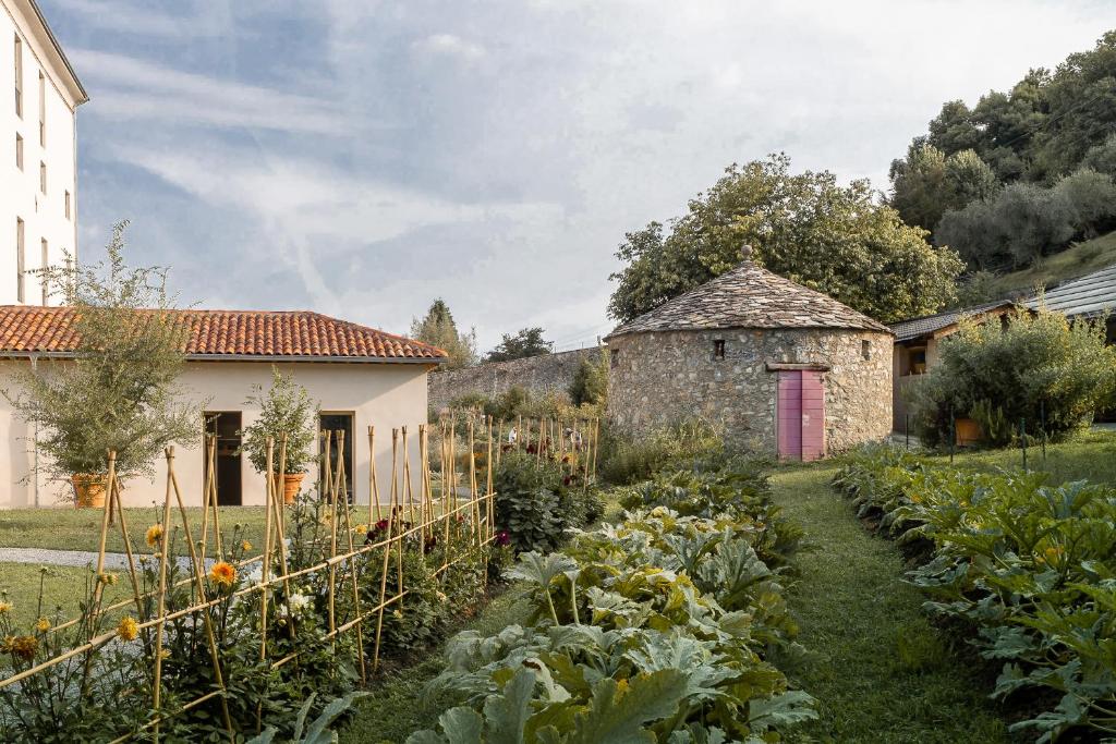 
a garden area with a fence and a building at Agriturismo La Derta in Bellagio
