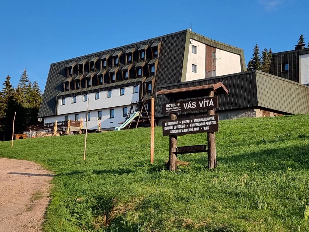 ein Schild im Gras vor einem Gebäude in der Unterkunft Cerna Bouda in Janské Lázně