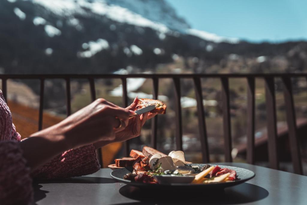 a woman sitting at a table with a plate of food at Boutique Hotel Glacier in Grindelwald