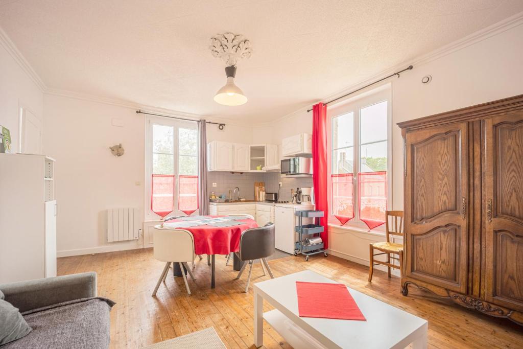 un salon avec une table et une cuisine dans l'établissement La Roseraie, à Bernières-sur-Mer