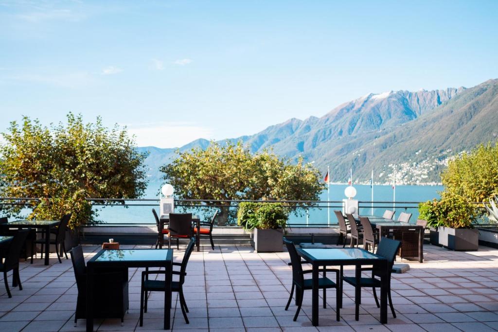a patio with tables and chairs and a view of the water at Casa al Portico (by La Meridiana) in Ascona