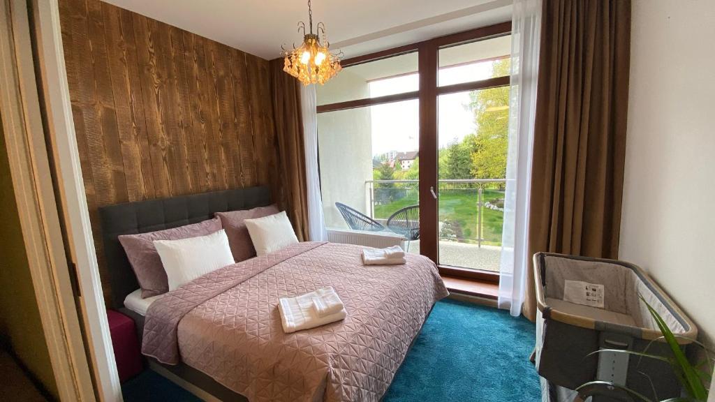 um quarto com uma cama e uma grande janela em Apartmán C110 v Hrebienok Resort II em Starý Smokovec