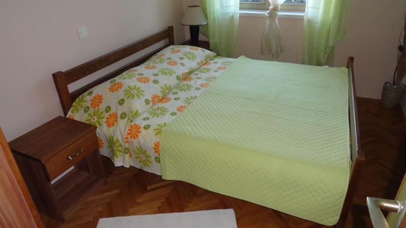 a bedroom with a bed with a green comforter at Apartment in Palit with Terrace, Air conditioning, Wi-Fi (4603-1) in Mundanije